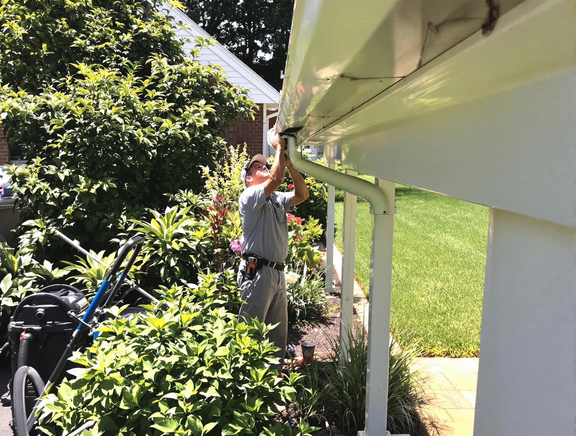 Technician flushing a blockage from a downspout in Fairview Park, OH